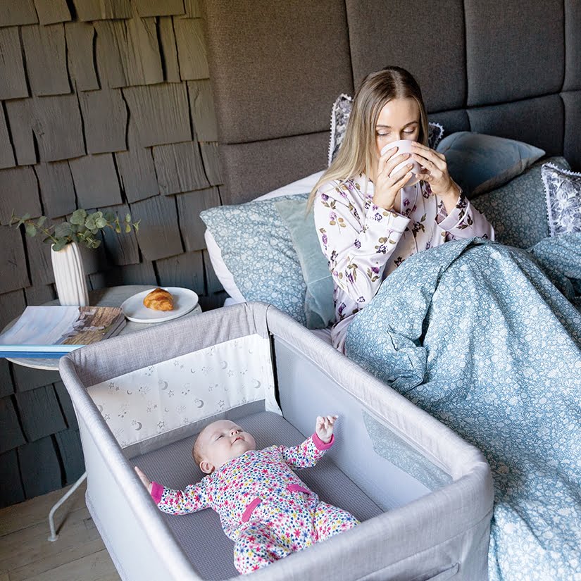 fb_20201025__roomie_glide__mum_holding_tea_in_bed_with_baby_next_1